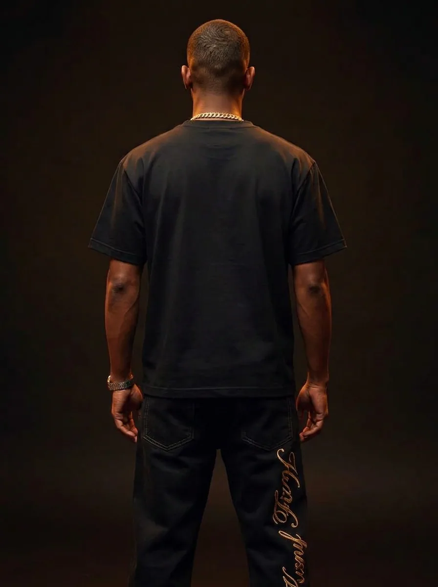 VVXHQ men's Gold Script Denim in Onyx Black — Baggy black denim with gold script embroidery, back view